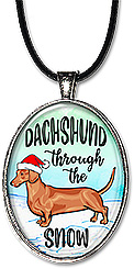 Whimsical handcrafted Christmas necklace features a dog with a Santa cap, with the message: 'dachshund through the snow', in your choice of pendant or keychain.