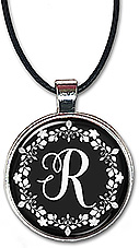 Striking black and white design is featured on this necklace or keychain with any initial centered in the white floral wreath.